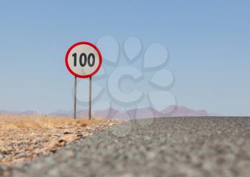 Speed limit sign at a desert road in Namibia, speed limit of 100 kph or mph