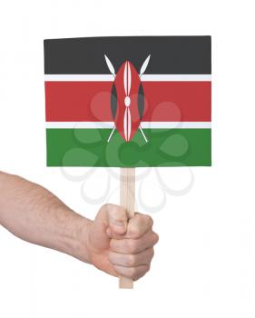Hand holding small card, isolated on white - Flag of Kenya