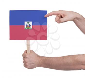 Hand holding small card, isolated on white - Flag of Haiti