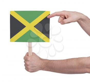 Hand holding small card, isolated on white - Flag of Jamaica