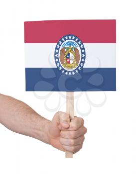 Hand holding small card, isolated on white - Flag of Missouri