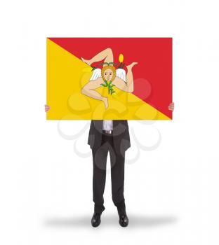 Smiling businessman holding a big card, flag of Sicily, isolated on white