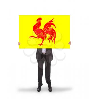 Smiling businessman holding a big card, flag of Wallonia, isolated on white