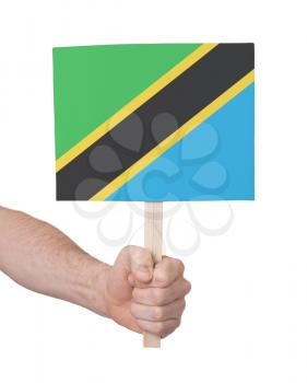 Hand holding small card, isolated on white - Flag of Tanzania