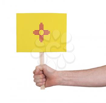 Hand holding small card, isolated on white - Flag of New Mexico