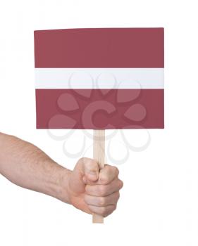 Hand holding small card, isolated on white - Flag of Latvia