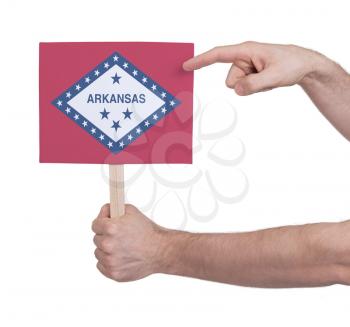 Hand holding small card, isolated on white - Flag of Arkansas