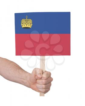 Hand holding small card, isolated on white - Flag of Liechtenstein