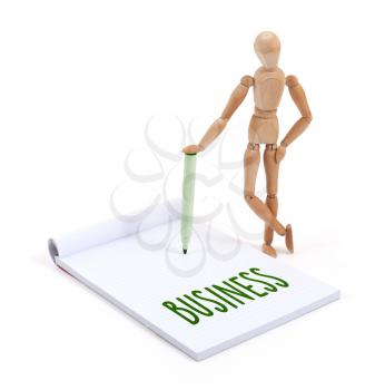 Wooden mannequin writing in a scrapbook - Business