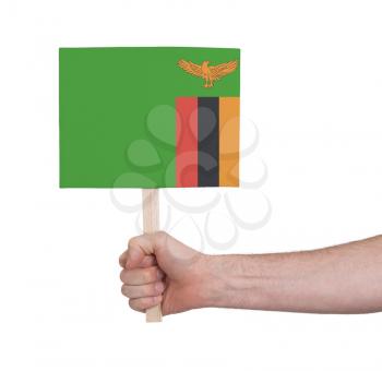 Hand holding small card, isolated on white - Flag of Zambia