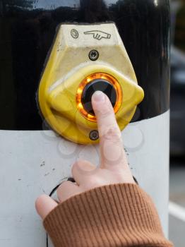 Female hand pushing button for traffic light