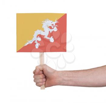 Hand holding small card, isolated on white - Flag of Bhutan