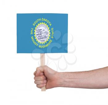 Hand holding small card, isolated on white - Flag of South Dakota