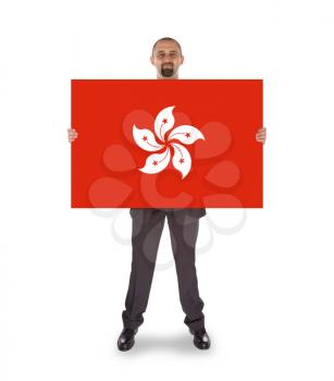 Smiling businessman holding a big card, flag of Hong Kong, isolated on white