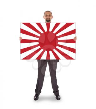 Smiling businessman holding a big card, flag of Japan, isolated on white