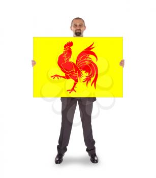 Smiling businessman holding a big card, flag of Wallonia, isolated on white