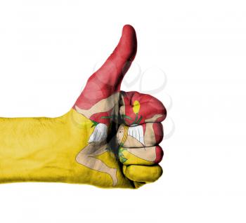 Closeup of male hand showing thumbs up sign, flag of Sicily