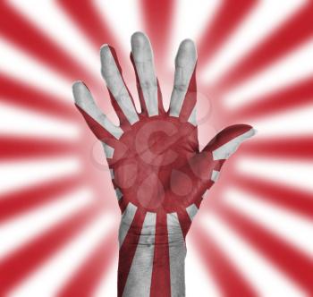 Palm of a woman hand, painted with flag of Japan