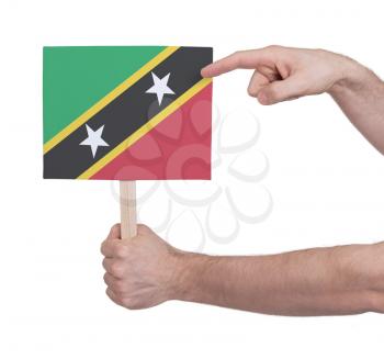 Hand holding small card, isolated on white - Flag of Saint Kitts and Nevis