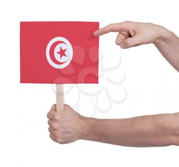 Hand holding small card, isolated on white - Flag of Tunisia