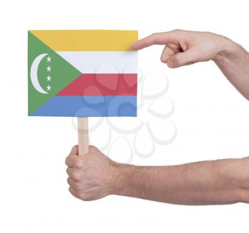 Hand holding small card, isolated on white - Flag of Comoros