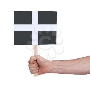 Hand holding small card, isolated on white - Flag of Cornwall