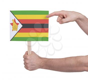 Hand holding small card, isolated on white - Flag of Zimbabwe