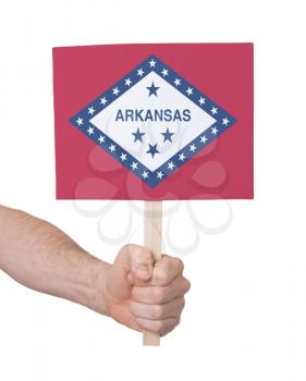 Hand holding small card, isolated on white - Flag of Arkansas