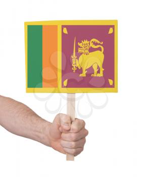 Hand holding small card, isolated on white - Flag of Sri Lanka