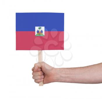 Hand holding small card, isolated on white - Flag of Haiti