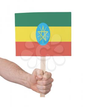 Hand holding small card, isolated on white - Flag of Ethiopia