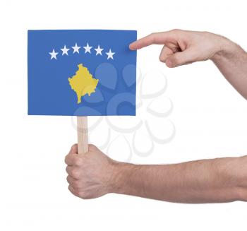 Hand holding small card, isolated on white - Flag of Kosovo