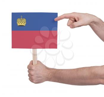 Hand holding small card, isolated on white - Flag of Liechtenstein