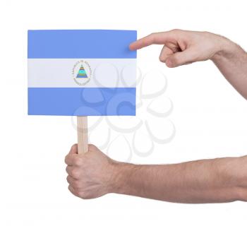 Hand holding small card, isolated on white - Flag of Nicaragua