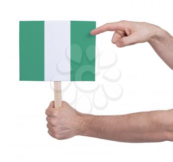 Hand holding small card, isolated on white - Flag of Nigeria