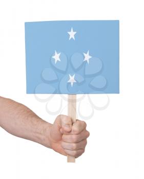 Hand holding small card, isolated on white - Flag of Micronesia