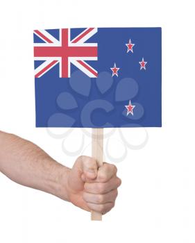 Hand holding small card, isolated on white - Flag of New Zealand