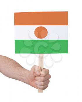Hand holding small card, isolated on white - Flag of Niger