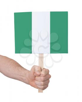 Hand holding small card, isolated on white - Flag of Nigeria