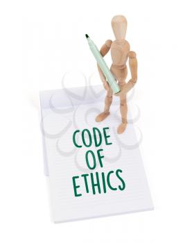 Wooden mannequin writing in a scrapbook - Code of ethics