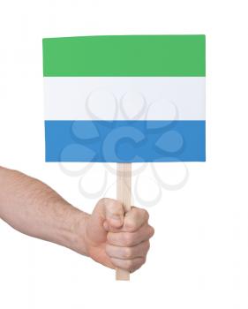 Hand holding small card, isolated on white - Flag of Sierra Leone