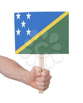 Hand holding small card, isolated on white - Flag of Solomon Islands