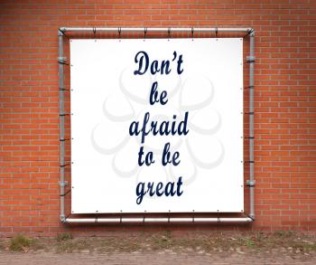 Large banner with inspirational quote on a brick wall - Don't be afraid to be great