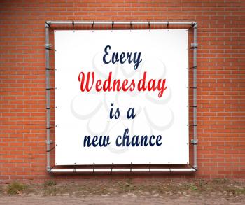Large banner with inspirational quote on a brick wall - Every wednesday is a new chance