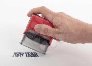 Plastic stamp in hand, isolated on white - New year
