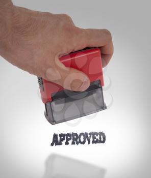 Plastic stamp in hand, isolated on white - Approved