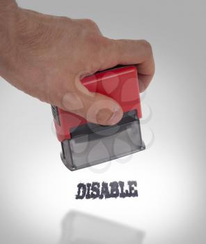Plastic stamp in hand, isolated on white - Disable