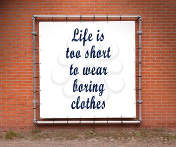 Large banner with inspirational quote on a brick wall - Life is to short to wear boring clothes