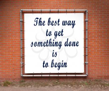 Large banner with inspirational quote on a brick wall - The best way to get something done is to begin