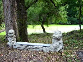 Original bench with figures in the park with lake